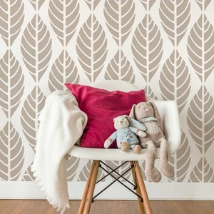 May include: A white chair with a red cushion and two plush toys. The chair is in front of a wall with a brown leaf pattern.