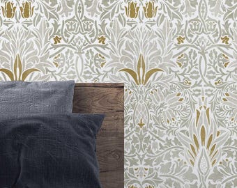 May include: A white wallpaper with a repeating pattern of gold and gray stylized floral designs. The wallpaper is shown on a wall behind a bed with a gray headboard and two gray pillows.