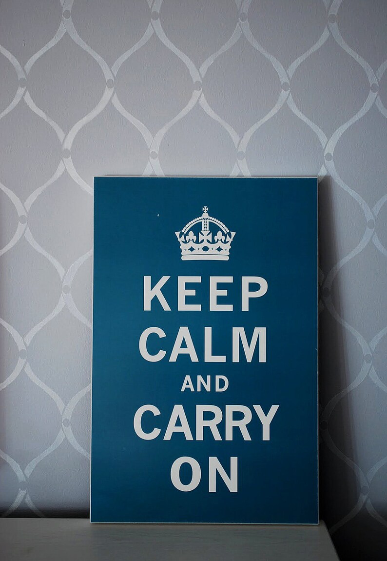 May include: A teal blue sign with a white crown and the text "Keep Calm and Carry On".