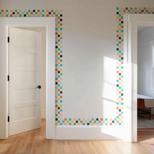 May include: A white wall with a border of colorful square tiles. The tiles are arranged in a vertical line and are in various colors, including orange, yellow, blue, and black. A white door is open to the left, and another doorway is visible on the right.