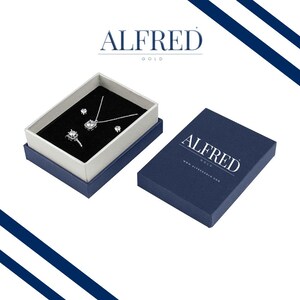 May include: A blue jewelry box with a white interior, containing a silver necklace, a ring, and a pair of earrings. The box is labeled "Alfred Gold" and has the website address printed on the bottom.
