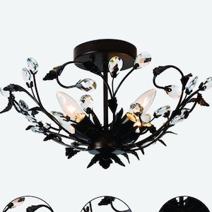 May include: A black, floral-themed ceiling light fixture. The fixture features a circular design with crystal accents and three light bulbs. The metal frame has a dark finish, and the design includes leaf and flower details.
