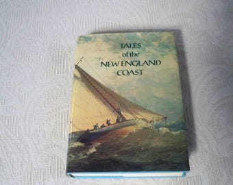 May include: A hardcover book titled Tales of the New England Coast featuring a painted illustration of a sailboat navigating choppy ocean waves under a cloudy sky. The cover art displays a vessel with white sails and several figures on deck.