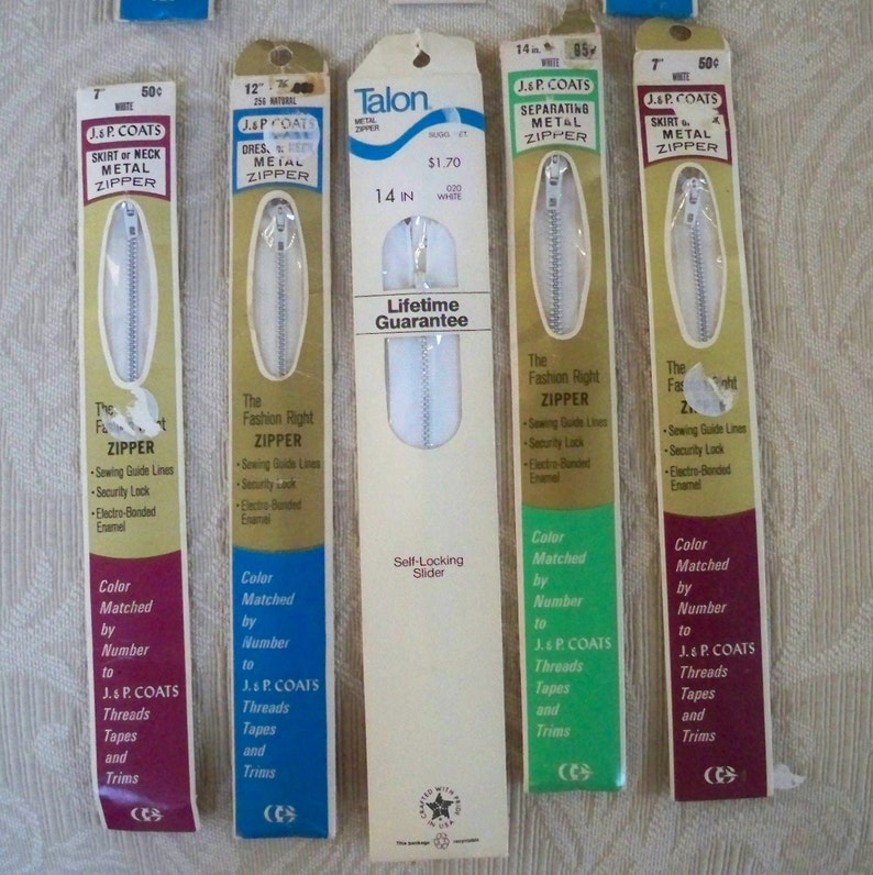 May include: Four packages of J. & P. Coats metal zippers in various colors and lengths. The packages feature the brand name, zipper type, and size. One package is for a 14-inch separating zipper and features the Talon brand name with a lifetime guarantee.
