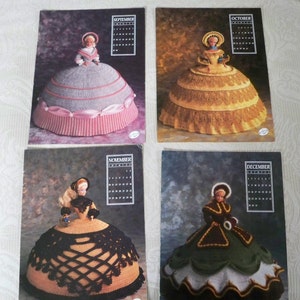 May include: Four crochet doll dress patterns featuring a calendar for each month. The dresses are in different colors and styles, including a gray dress with pink trim, a yellow dress with gold trim, a black and gold dress, and a green dress with brown and white trim.