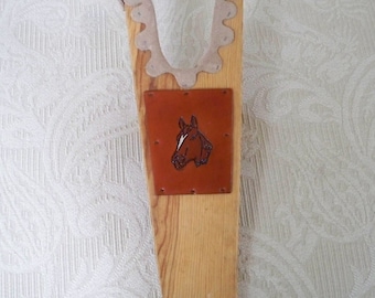 Zapato de bota vintage estilo western con herradura y cabeza de caballo de madera.