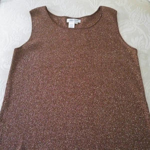 May include: A sleeveless, brown metallic knit top with a scoop neckline. The top has a subtle shimmer and a relaxed fit. The tag reads "Calvin Klein".