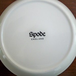 May include: White ceramic plate with a black "Spode England" logo in a gothic font.
