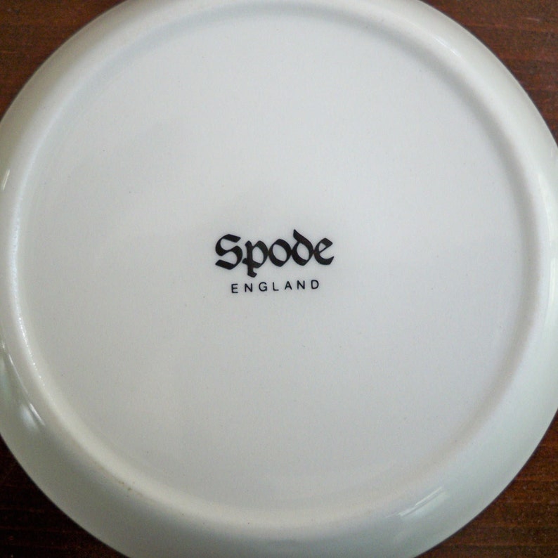 May include: White ceramic plate with a black "Spode England" logo in a gothic font.