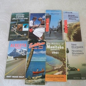 May include: A collection of vintage Canadian road maps, including Ontario, Alberta, and Manitoba. The maps feature colorful covers with scenic views and text. The maps are from the 1960s and 1970s.