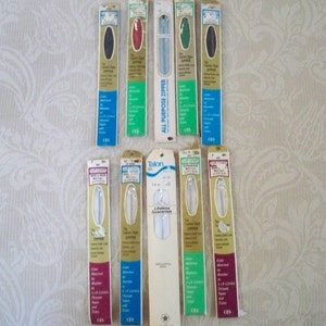 May include: A collection of 12 white, black, red, green, and silver zippers in individual packaging. The packaging features the brand name "Talon" and the text "Lifetime Guarantee".