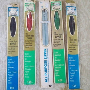 May include: Four packages of J & P Coats zippers, each with a different color zipper. The packages are labeled "The Fashion Right Zipper" and include information about the zipper's features, such as sewing guide lines, security lock, and electro-bonded enamel. The zippers are color matched by number to J & P Coats threads, tapes, and trims.