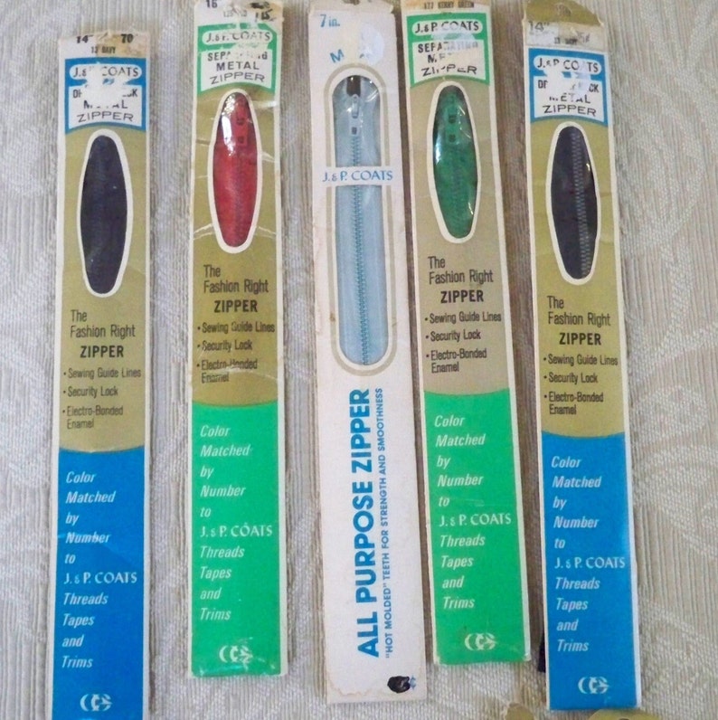 May include: Four packages of J & P Coats zippers, each with a different color zipper. The packages are labeled "The Fashion Right Zipper" and include information about the zipper's features, such as sewing guide lines, security lock, and electro-bonded enamel. The zippers are color matched by number to J & P Coats threads, tapes, and trims.
