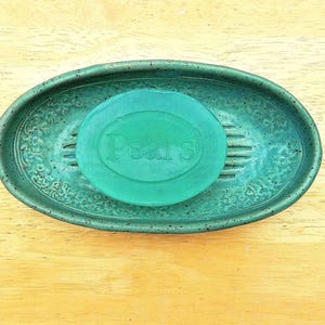 May include: A green ceramic soap dish with a raised design and a green bar of soap with the word "Pears" printed on it.