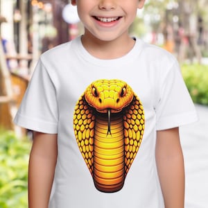 May include: A white t-shirt featuring a graphic of a yellow cobra with its hood raised. The cobra has black eyes and a black tongue.