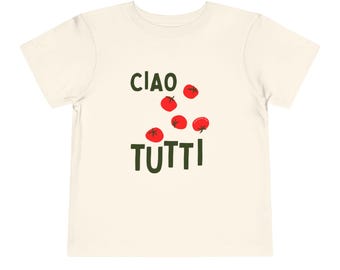 Puede incluir: Camiseta crema para niños pequeños con las palabras italianas "CIAO TUTTI" en verde oscuro, acompañadas de ilustraciones de tomates rojos. La camiseta está hecha de tela suave y es adecuada para ropa casual.
