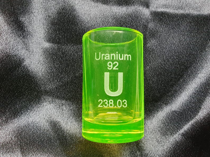 May include: A green shot glass with the text "Uranium 92 U 238.03" printed on it.