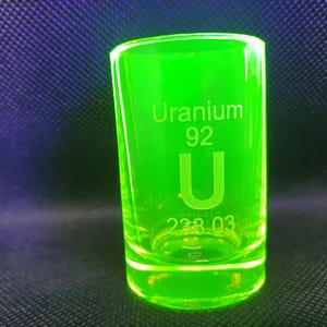 May include: A green shot glass with the words "Uranium 92 U 238.03" etched on the side.