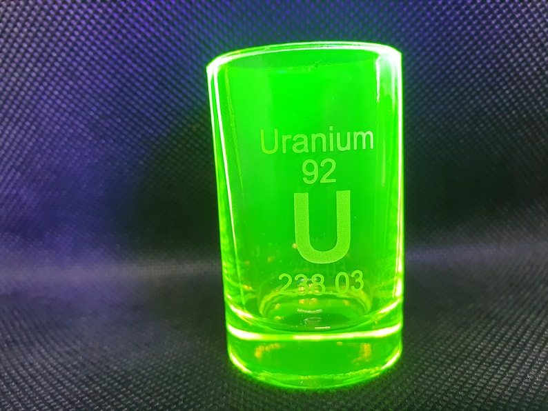 May include: A green shot glass with the words "Uranium 92 U 238.03" etched on the side.