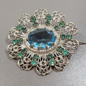 blue rhinestone brooch flower shaped silvertone metal filigree