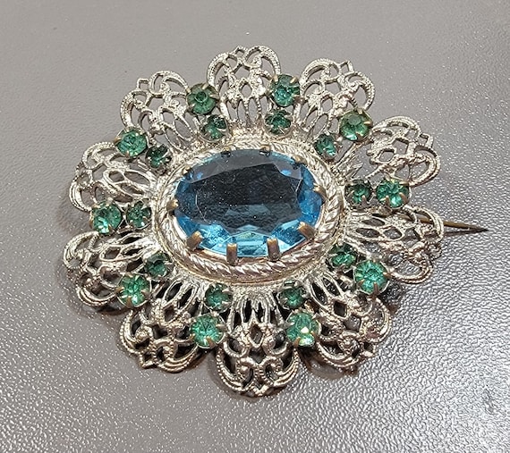 blue rhinestone brooch flower shaped silvertone metal filigree