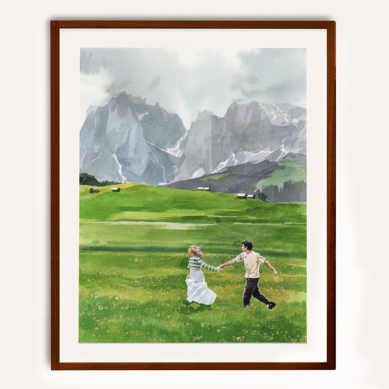 May include: Watercolour print of a couple running through a green meadow with mountains in the background. The artwork is framed in a dark brown wooden frame. The couple is holding hands, and the woman is wearing a white dress.