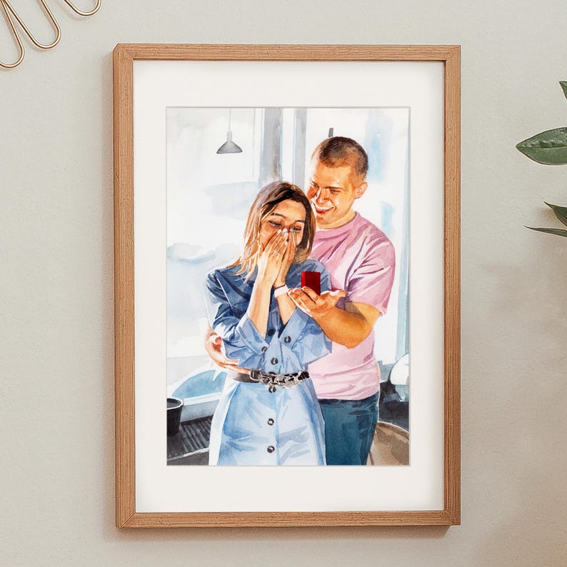 May include: Watercolor painting in a wooden frame depicts a proposal scene. A woman in a blue dress covers her mouth, reacting to a man holding a ring box. The man wears a pink shirt, smiling. The artwork is set against a window background.