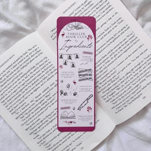 May include: A pink bookmark with a white outline of a book and the words "Thriller Book Club Ingredients" in a white heart. The bookmark has a list of "Ingredients" for a murder mystery, including crime scene caution tape, hand prints, a murder weapon, and a suspect's warning.