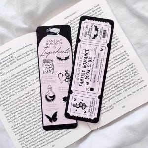 May include: A black and pink bookmark with a fantasy romance theme. The bookmark features a ticket with the text "Official Member of the Fantasy Romance Book Club" and a list of ingredients for a fantasy romance potion, including a black heart and dagger, a bottle of moonlight, and a black rose.