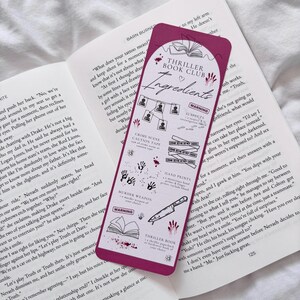 May include: A pink bookmark with a red heart and the text "Thriller Book Club Ingredients" in white. The bookmark features illustrations of crime scene tape, hand prints, a murder weapon, a book, and a warning sign. The bookmark is designed to look like a crime scene.