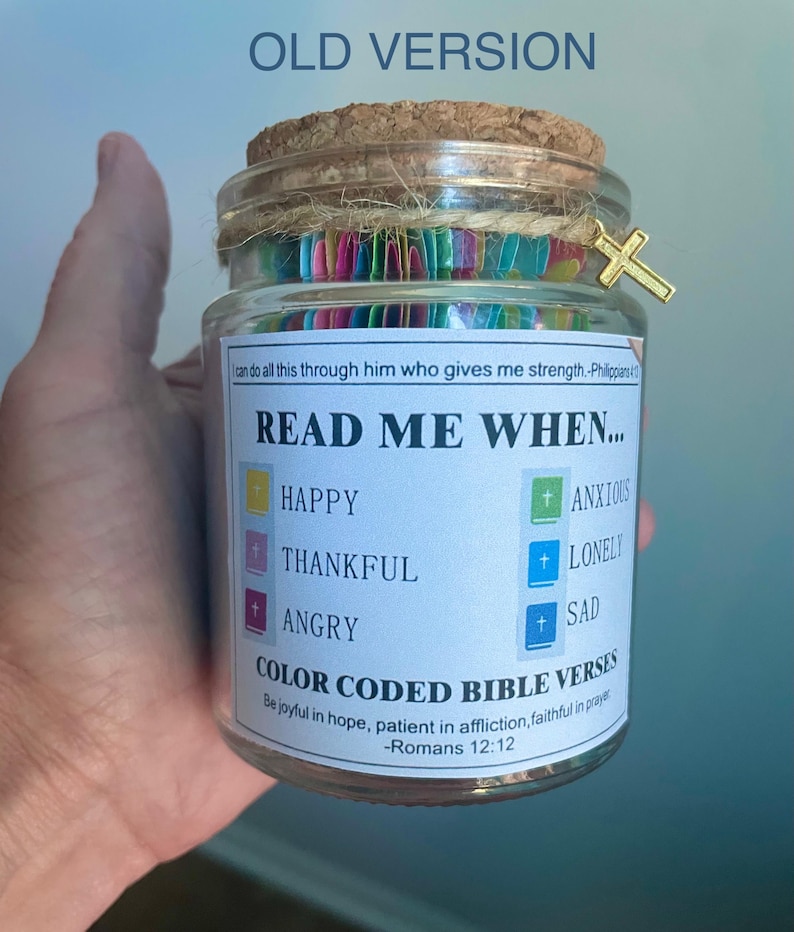 May include: A glass jar with a cork lid and a gold cross charm. The jar contains colorful paper strips and a label that reads "READ ME WHEN..." with prompts for different emotions. The text also includes Bible verses.
