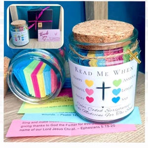May include: A glass jar with a cork lid and a decorative cross charm. The jar is labeled "Read Me When" and contains colorful, color-coded scripture notes. The jar is a unique gift idea.