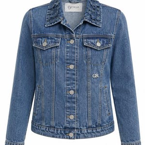 Puede incluir: Una chaqueta de mezclilla azul de tono medio con un cuello adornado con aplicaciones de flores de tela, cierre frontal de botones, dos bolsillos en el pecho con solapas abotonadas y las letras GR bordadas en el pecho izquierdo. La etiqueta dice Georgia.