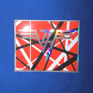 May include: Square sticker with a red background and a black, white, and silver graphic design. The design features the letters "VH" in silver with a rainbow holographic effect. The sticker has a clear border.