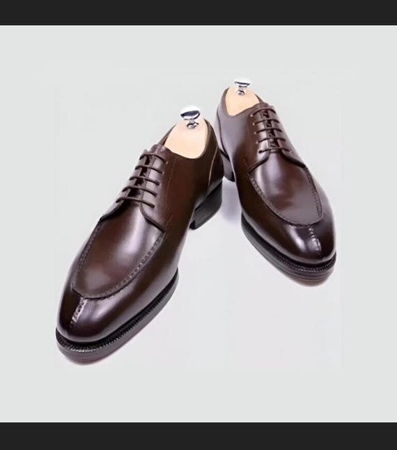 Luxury brown leather brogues, classic lace-up dress shoes.