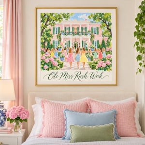 Op de afbeelding: Een ingelijste kunstdruk met een schilderij van een groot roze huis met witte zuilen en groene luiken. Een groep mensen in kleurrijke jurken staat voor het huis tussen roze hortensia's. De tekst Ole Miss Rush Week staat onderaan.