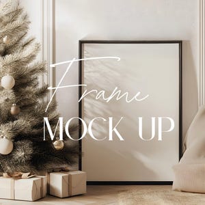 Könnte beinhalten: Ein schwarzer Rahmen-Mockup mit dem Text "Frame Mock Up" in weißen Buchstaben. Der Rahmen lehnt an einer weißen Wand mit einem Weihnachtsbaum und verpackten Geschenken im Vordergrund.