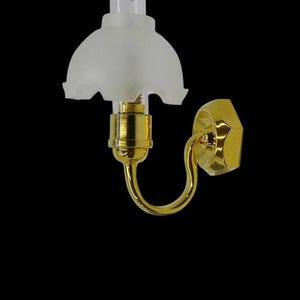 Op de afbeelding: Een miniatuur wandlamp met een gouden afwerking en een matglazen kap. De lamp heeft een gebogen arm en een zeshoekige basis. De tekst "FA012017" staat onderaan afgedrukt.