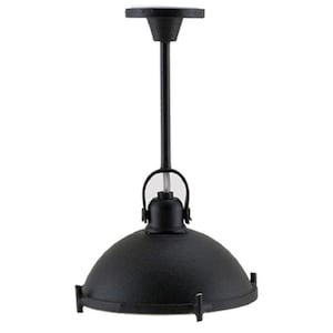 Op de afbeelding: Een matzwarte hanglamp met een koepelvormige kap met een getextureerde afwerking. De lamp hangt aan een dunne verticale stang die verbonden is met een ronde plafondbevestiging, met een kleine boogvormige beugel die de kap aan de stang bevestigt.