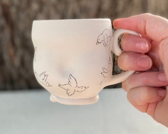 Porcelain mug with inlaid whimsical birds and clear glaze