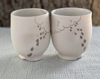 Porcelain cup with inlaid rain cloud design  and clear glaze and real palladium overglaze raindrops