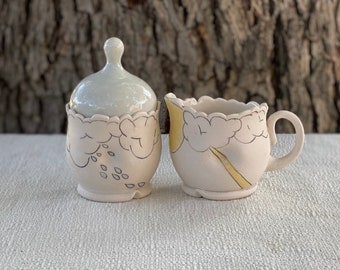 Cream and sugar set with Inlaid rainy while sunny scene