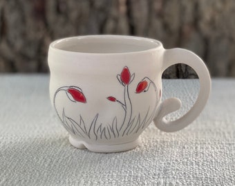 Porcelain mug with inlaid whimsical flower buds and red and clear glaze