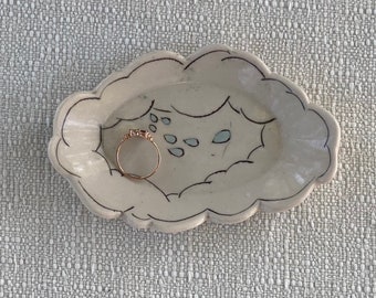 Charming ring dish with carved rim and inlaid whimsical rain cloud design and blue and clear glaze