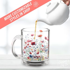 May include: A clear glass mug with a floral design featuring pink, red, and blue flowers. The mug has a handle and is filled with brown liquid. The text "More Customizable Styles in Shop" is visible in the background.