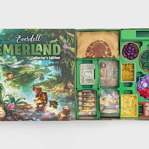 Könnte beinhalten: Everdell Emerland Collector's Edition Brettspielschachtel mit einer Fantasy-Waldillustration und einem Wasserschwein. Die geöffnete Schachtel zeigt einen grünen Kunststoffeinsatz mit violetten Beeren, grünen Blättern, goldenen Münzen, roten und rosa Spielsteinen sowie hölzernen Baumstämmen.