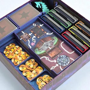 May include: A board game organiser with various compartments. The organiser contains stacks of cards, game tokens, and card holders in different colours. The tokens are gold with black numbers. The organiser is purple and blue.