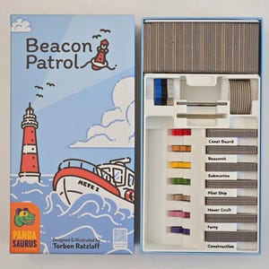 Könnte beinhalten: Brettspiel "Beacon Patrol" mit einer Illustration eines Leuchtturms und eines Bootes auf der Schachtel. Die offene Schachtel zeigt Spielsteine und Karten mit der Aufschrift "Küstenwache", "Forschung" und mehr. Die Schachtel ist hellblau.