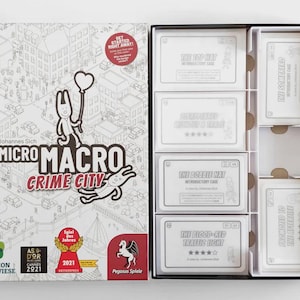 May include: A board game box labelled "MicroMacro Crime City" with a cartoon illustration and the text "Get Started Right Away!". The game includes cards with case titles such as "The Top Hat" and "The Blood-Red Traffic Light".