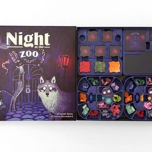 Könnte beinhalten: Ein Brettspiel mit dem Titel Night at the Zoo in einer dunkelvioletten Schachtel, die einen Wolf, einen Leoparden und Laternen zeigt. Die offene Schachtel enthält einen Kunststoffeinsatz mit bunten Spielsteinen, quadratischen Plättchen und einer Wolfsfigur.